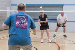 Image of players playing badminton from the perspective of a player receiving a serve.